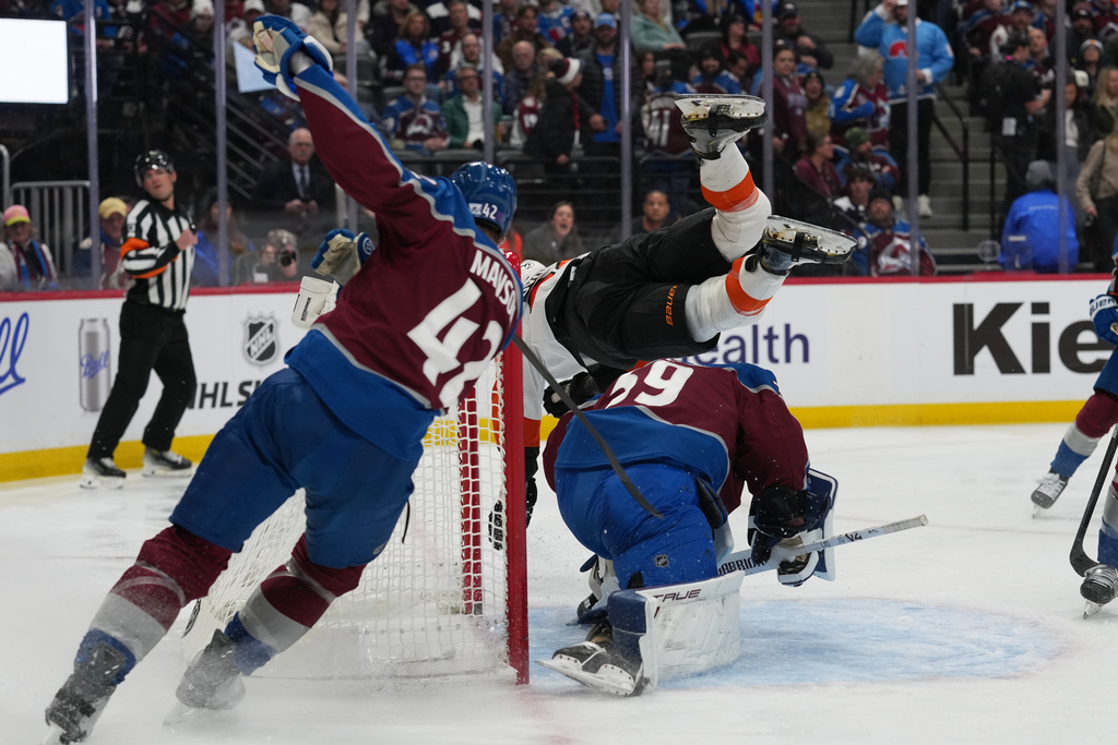 Colorado Avalanche defenseman Josh Manson, left, tries to stop after propelling Philadelphia Flyers center Christian Dvorak, top right, into Avalanche goaltender MacKenzie Blackwood, bottom right, in the second period of an NHL hockey game Friday, Jan. 23, 2026, in Denver. (AP Photo/David Zalubowski)