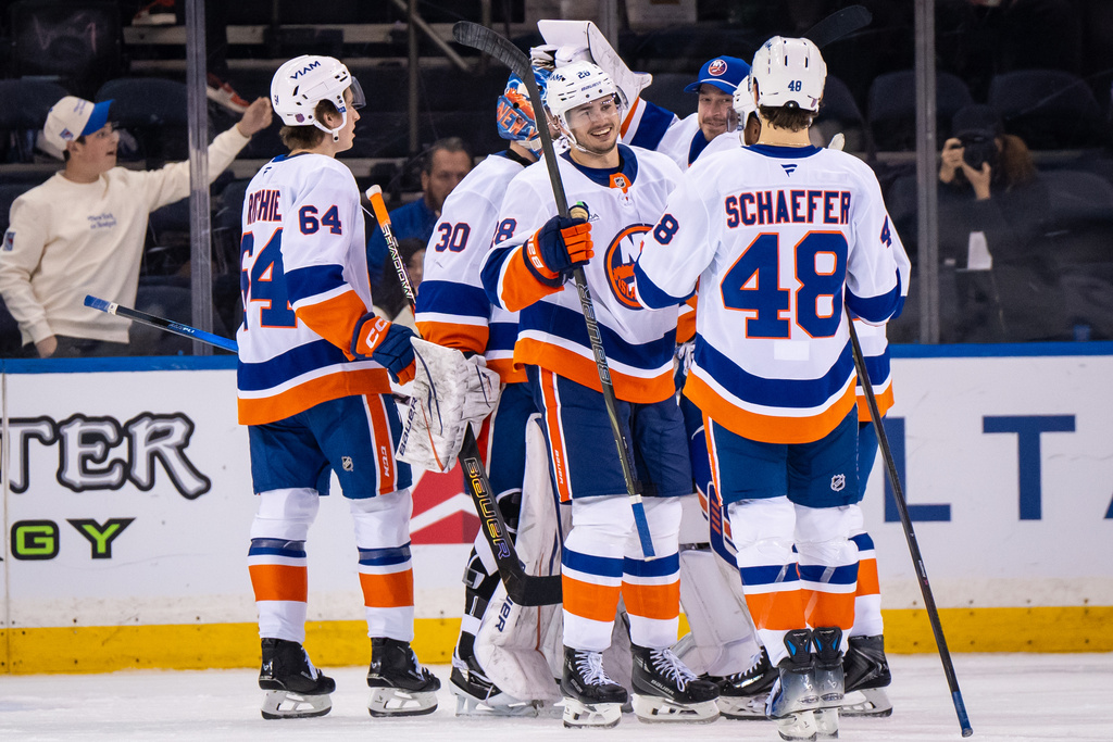 New York Islanders players congratulate each other after a win against the New York Rangers during an NHL hockey game, Saturday, Nov. 8, 2025, in New York. (AP Photo/Angelina Katsanis)