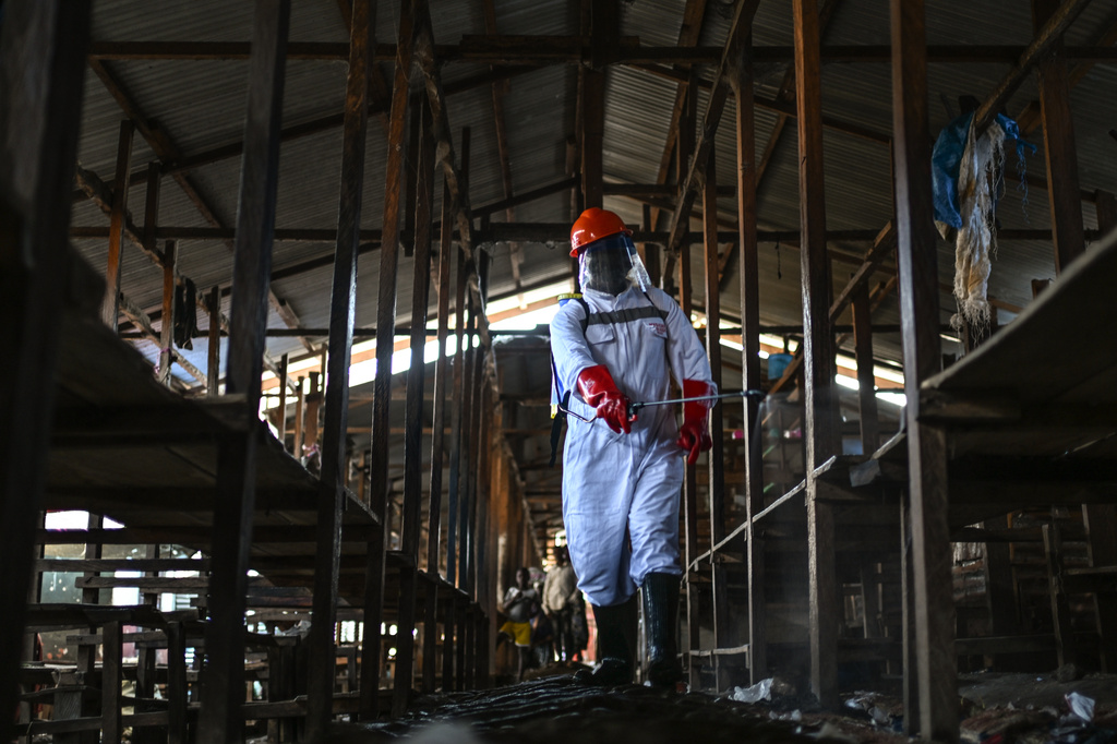 A sanitation worker from the Bunia city government sprays chlorine to disinfect the central market, as Ituri province continues to combat an Ebola outbreak, in Bunia, Congo, Saturday, May 23, 2026. (AP Photo/Moses Sawasawa)