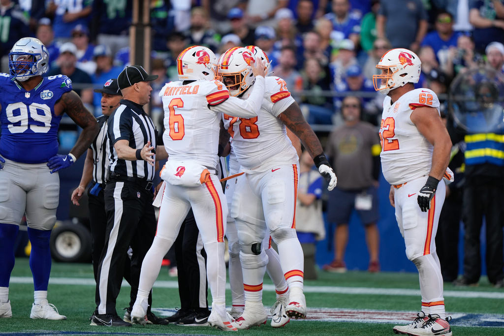 Tampa Bay Buccaneers quarterback Baker Mayfield (6) and offensive tackle Tristan Wirfs (78) celebrate after a penalty was called on the Seattle Seahawks during the second half of an NFL football game Sunday, Oct. 5, 2025, in Seattle. (AP Photo/Stephen Brashear)