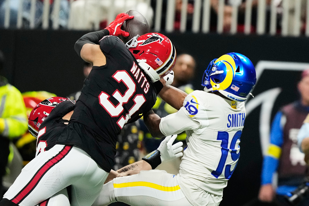 Atlanta Falcons safety Xavier Watts (31) intercepts a pass intended for Los Angeles Rams wide receiver Xavier Smith (19) in the first half of an NFL football game, Monday, Dec. 29, 2025, in Atlanta. (AP Photo/Brynn Anderson)