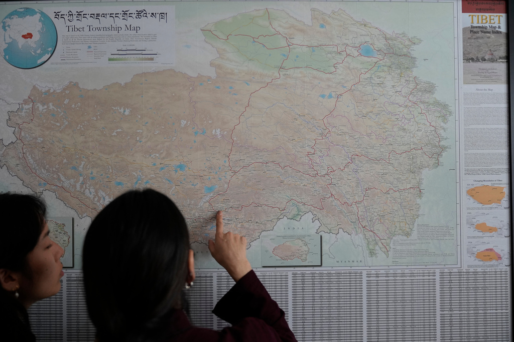 Namkyi, right, a Tibetan former political prisoner who was arrested at 15 for protesting Chinese rule, shows the route she took when she escaped and crossed into Nepal to Tsejin Khando, with the International Campaign for Tibet, Oct. 8, 2025, at the Office of Tibet in Washington. (AP Photo/David Goldman)