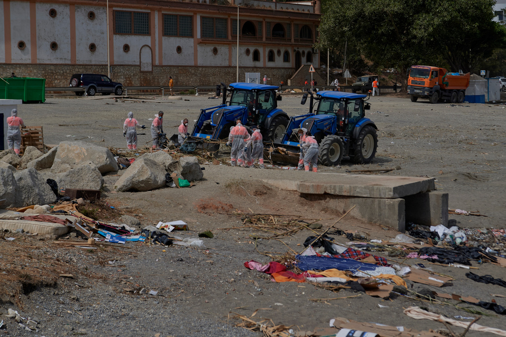 Cleaning staff clear the El Trampolin beach, where migrants who crossed from Morocco into Spain stayed in the Spanish exclave of Ceuta, Thursday, Aug. 20, 2026. (AP Photo/Antonio Sempere)