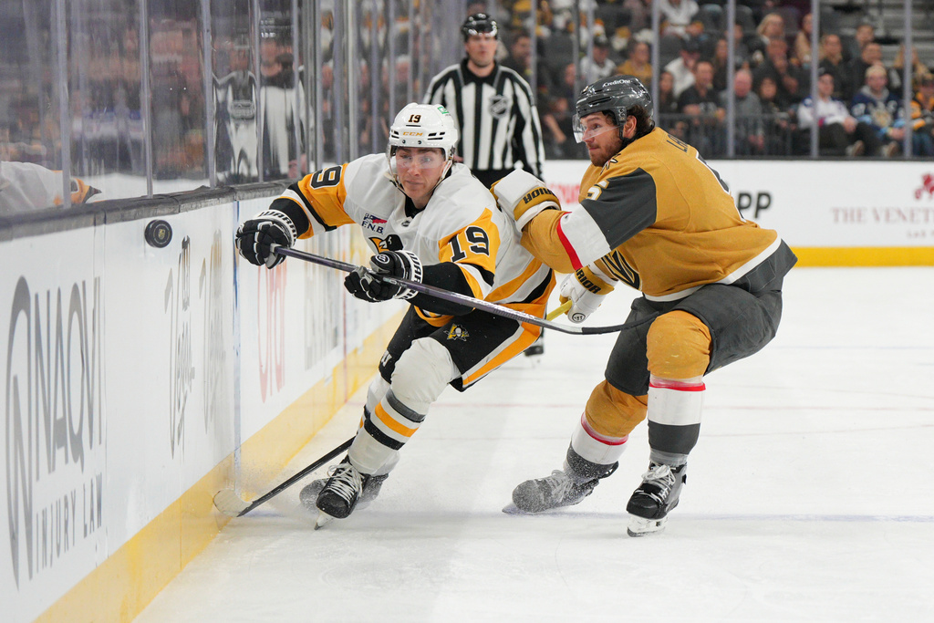 Vegas Golden Knights defenseman Jeremy Lauzon (5) collides with Pittsburgh Penguins center Connor Dewar (19) during the first period of an NHL hockey game Thursday, March 12, 2026, in Las Vegas. (AP Photo/Candice Ward)