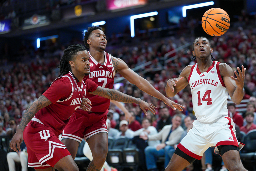 Louisville guard Adrian Wooley, right, goes for a rebound in front of Indiana's Nick Dorn, center, and Lamar Wilkerson during an NCAA college basketball game in Indianapolis, Saturday, Dec. 6, 2025. (AP Photo/AJ Mast)