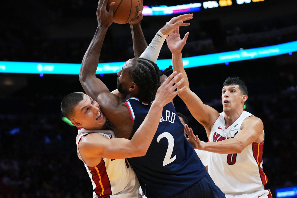 Los Angeles Clippers forward Kawhi Leonard (2) is fouled by Miami Heat guard Tyler Herro, left, during the second half of an NBA basketball game, Monday, Dec. 1, 2025, in Miami. (AP Photo/Lynne Sladky)