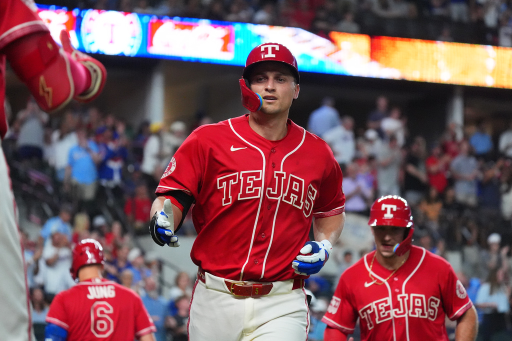 Texas Rangers' Corey Seager, center, jogs to the dugout after hitting a home run during the sixth inning of a baseball game against the Cleveland Guardians, Friday, June 5, 2026, in Arlington, Texas. (AP Photo/LM Otero)