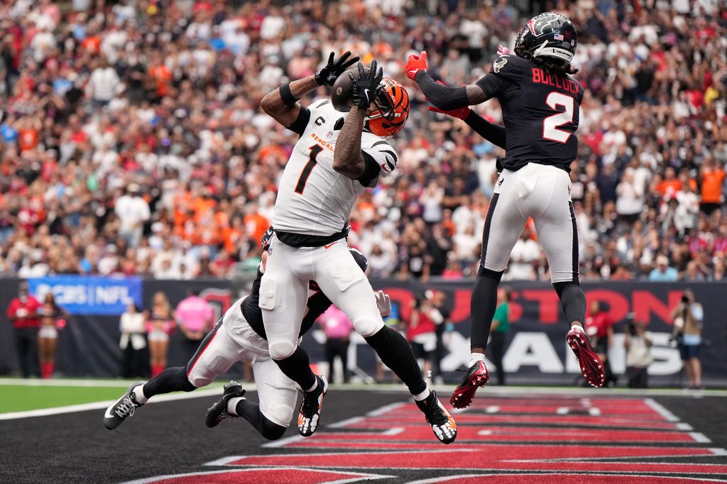Cincinnati Bengals wide receiver Ja'marr Chase (1) catches a pass for a touchdown as Houston Texans safety Reed Blankenship, behind, and safety Calen Bullock (2) try to defend during the second half of an NFL football game in Houston, Sunday, Sept. 20, 2026. (AP Photo/Ashley Landis)