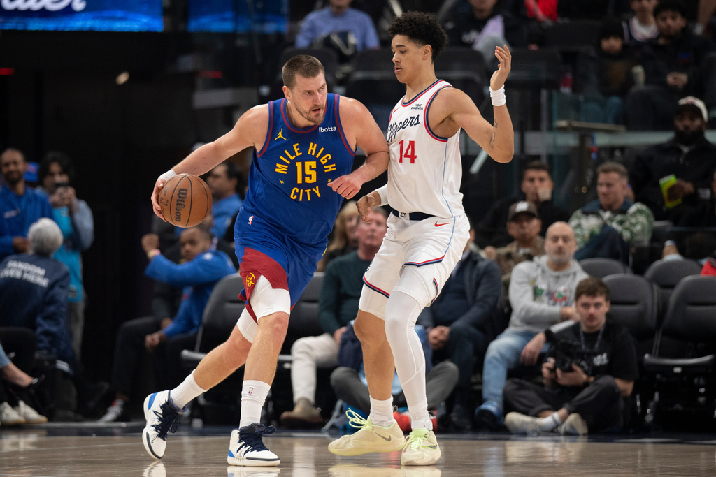 Denver Nuggets center Nikola Jokic (15) drives to the basket as Los Angeles Clippers center Yanic Konan Niederhauser (14) defends during the first half of an NBA basketball game Thursday, Feb. 19, 2026, in Inglewood, Calif. (AP Photo/Kyusung Gong)