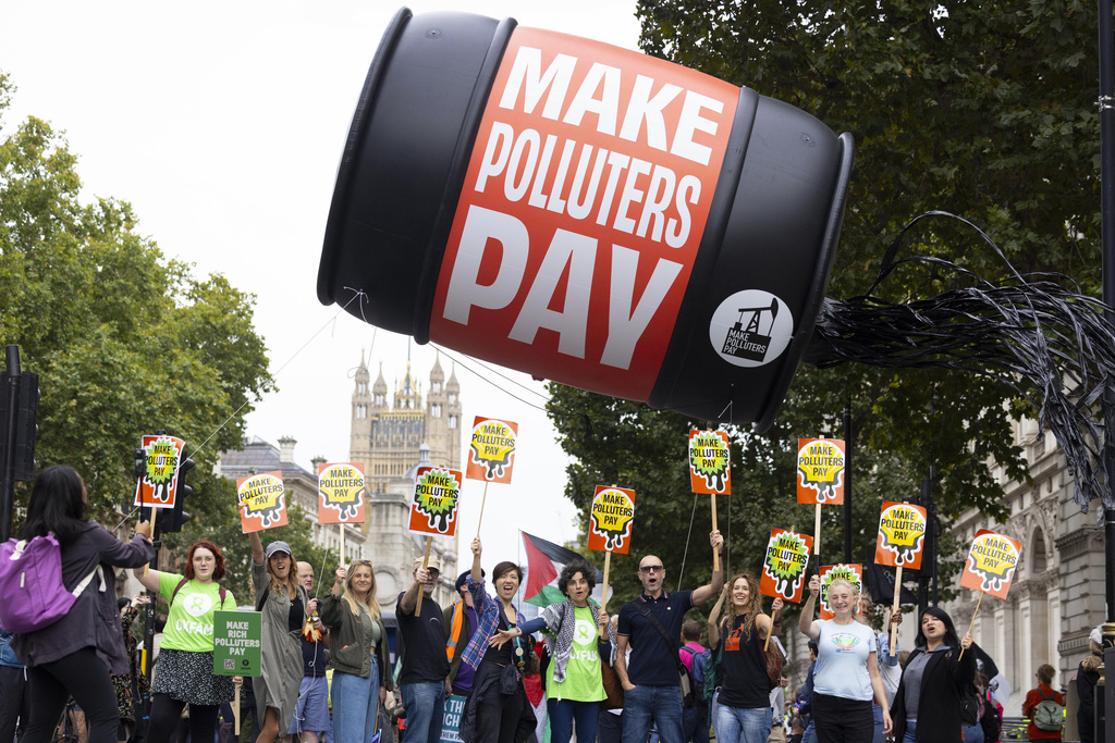Protesters with "Make Polluters Pay" campaign, calling on billionaires and fossil fuel companies to contribute financially to climate action, demonstrate as part of a national demonstration demanding economic and climate justice, ahead of the 2025 United Nations Climate Change Conference and UK Autumn Budget, in London, Saturday Sept. 20, 2025. (David Parry/PA/PA via AP)