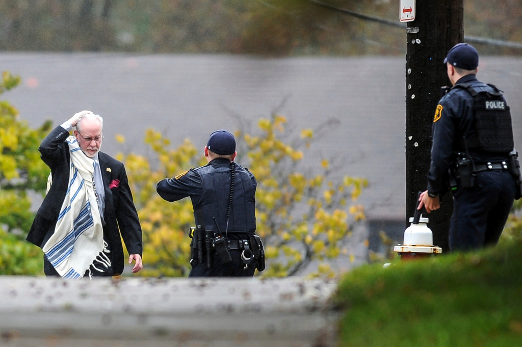 FILE - Rabbi Jeffrey Myers holds his head as he is escorted by police out of the Tree of Life Synagogue in the Squirrel Hill section of Pittsburgh, on Oct. 27, 2018, after a gunman fatally shot people while they worshipped. (Alexandra Wimley/Pittsburgh Post-Gazette via AP, File)
