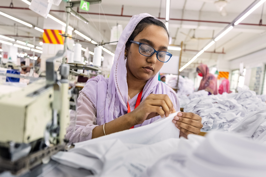 Ruma Aktar, a sewing machine operator, wears her prescription eyeglasses while working at a garment factory in Gazipur, on the outskirts of Dhaka, Bangladesh, June 30, 2026. (AP Photo/Rajib Dhar)