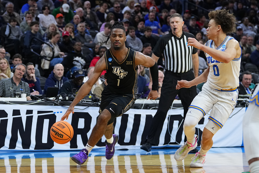 UCF's Themus Fulks (1) tries to get past UCLA's Trent Perryduring the first half in the first round of the NCAA college basketball tournament, Friday, March 20, 2026, in Philadelphia. (AP Photo/Matt Rourke)