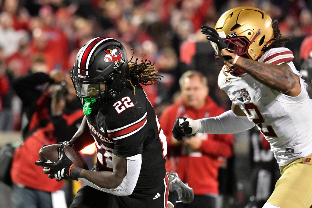 Louisville running back Keyjuan Brown (22) outruns the grasp of Boston College defensive back KP Price (2) during the second half of an NCAA college football game in Louisville, Ky., Saturday, Oct. 25, 2025. (AP Photo/Timothy D. Easley)