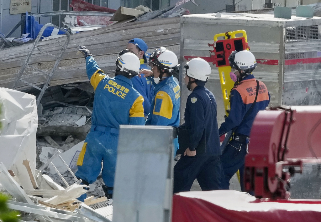 A firefighter carries a stretcher at AEON Mall shopping center, where an explosion occurred following a powerful earthquake, in Kashima, Kumamoto Prefecture, southern Japan, Thursday, July 30, 2026. (Kai Naito/Kyodo News via AP)