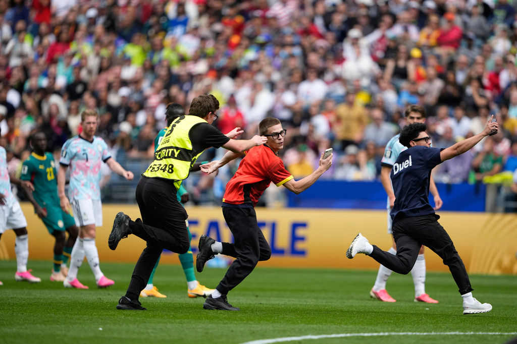 A security guard try to catch pitch invaders during the World Cup round of 32 soccer match between Belgium and Senegal in Seattle, Wednesday, July 1, 2026. (AP Photo/Lindsey Wasson)