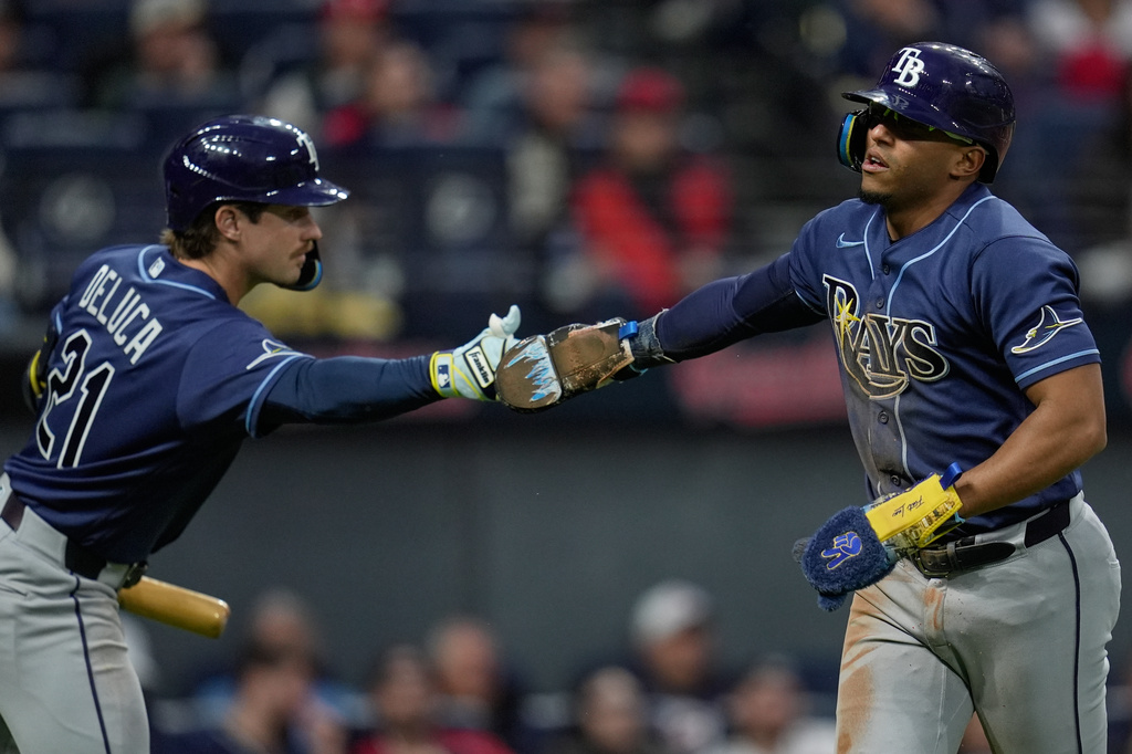 Tampa Bay Rays' Richie Palacios, right, is congratulated by Jonny DeLuca (21) after scoring in the eighth inning of a baseball game against the Cleveland Guardians in Cleveland, Monday, April 27, 2026. (AP Photo/Sue Ogrocki)