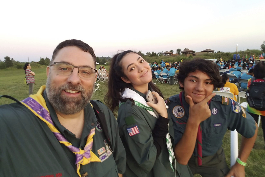 In this photo provided by Rashid Abdullah, from left, he, Shafiqah McLaughlin and his son, Nuruddin Abdul-Rashid, attend a Vietnamese Jamboree at Camp Snyder in Virginia on July 1, 2018. (Rashid Abdullah/National Association of Muslim Americans on Scouting via AP)
