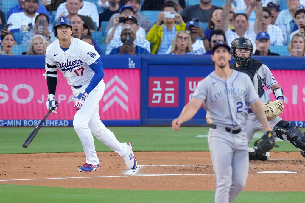 Los Angeles Dodgers' Shohei Ohtani, left, heads to first for a solo home run as Colorado Rockies starting pitcher Michael Lorenzen, center, and catcher Braxton Fulford watch during the first inning of a baseball game Tuesday, July 7, 2026, in Los Angeles. (AP Photo/Mark J. Terrill)