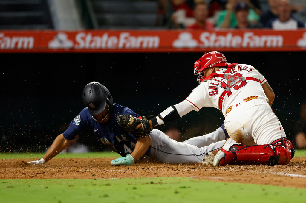 Los Angeles Angels catcher Moises Ballesteros (13), right, tags out Seattle Mariners' Julio Rodriguez (44), left, at home plate during the fifth inning of a baseball game Wednesday, Sept. 16, 2026, in Anaheim, Calif. (AP Photo/Caroline Brehman)