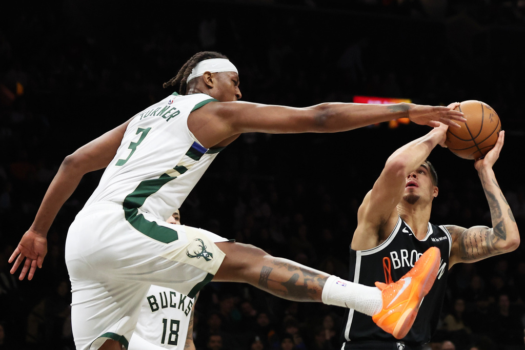 Brooklyn Nets forward Michael Porter Jr. gets Milwaukee Bucks center Myles Turner (3) up in the air while he drives to the basket during the first half of an NBA basketball game, Sunday, Dec. 14, 2025, in New York. (AP Photo/Heather Khalifa)