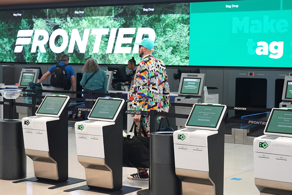 A traveller heads through a maze of empty kiosks to check in for a flight on Frontier Airlines in Denver International Airport Friday, Nov. 7, 2025, in Denver. (AP Photo/David Zalubowski)