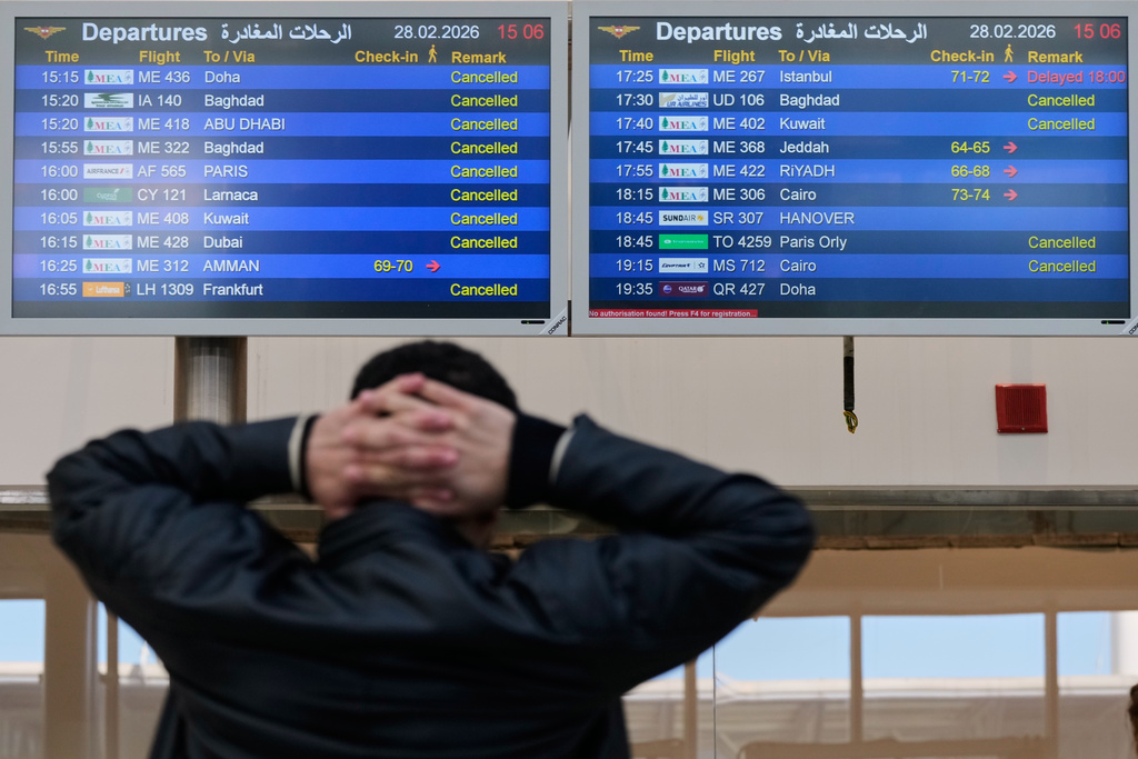 A traveler checks departure times as many flights are cancelled at Beirut Rafik Hariri International Airport in Beirut, Lebanon, Saturday, Feb. 28, 2026, as many airlines canceled flights due to the conflict involving the United States, Israel and Iran. (AP Photo/Hassan Ammar)