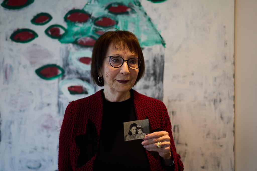 Holocaust survivor Ilana Kantorowicz Shalem, born in the Nazi Bergen-Belsen concentration camp, holds a photo of her with her mother Lola taken in the camp in 1946, in Tel Aviv, Israel, Jan. 26, 2026. (AP Photo/Ariel Schalit)