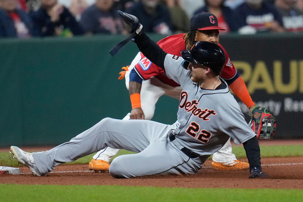 Detroit Tigers' Parker Meadows (22) advances to third base in front of Cleveland Guardians third baseman Jose Ramirez, rear, on an infield single hit by Javier Baez in the sixth inning of a baseball game in Cleveland, Thursday, Sept. 25, 2025. (AP Photo/Sue Ogrocki)