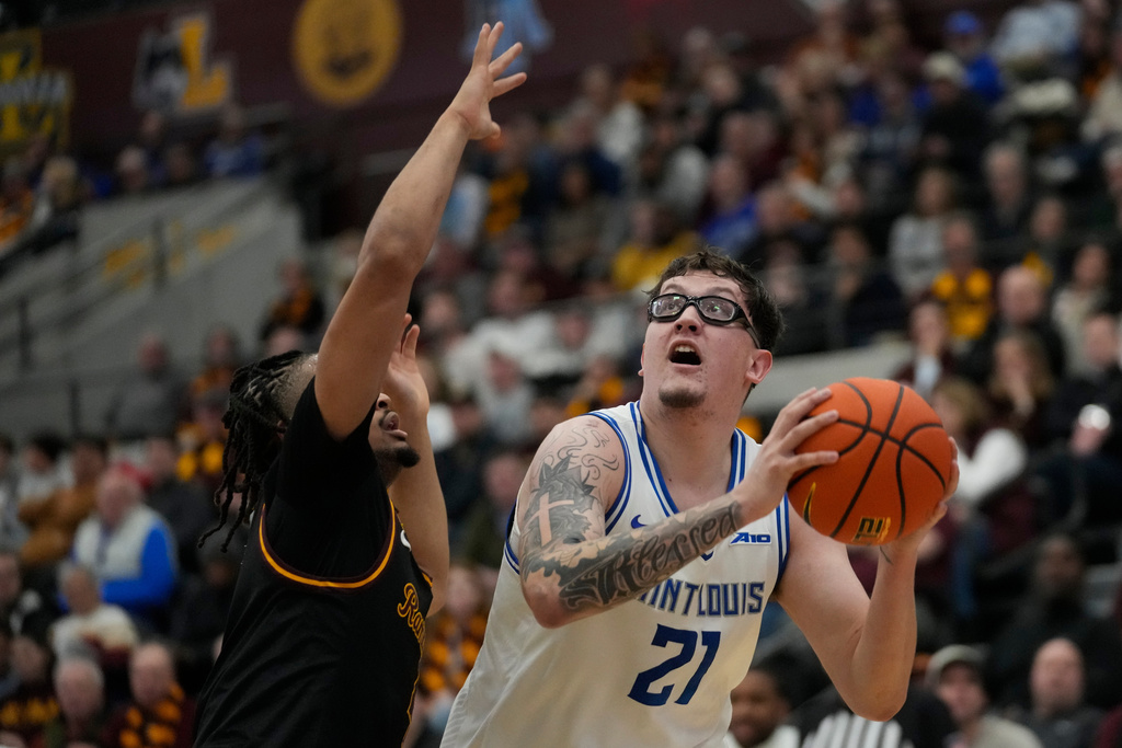 Saint Louis center Robbie Avila (21) handles the ball as Loyola Chicago guard Kayde Dotson, left, defends during the first half of an NCAA college basketball game Friday, Feb. 13, 2026, in Chicago. (AP Photo/Erin Hooley)