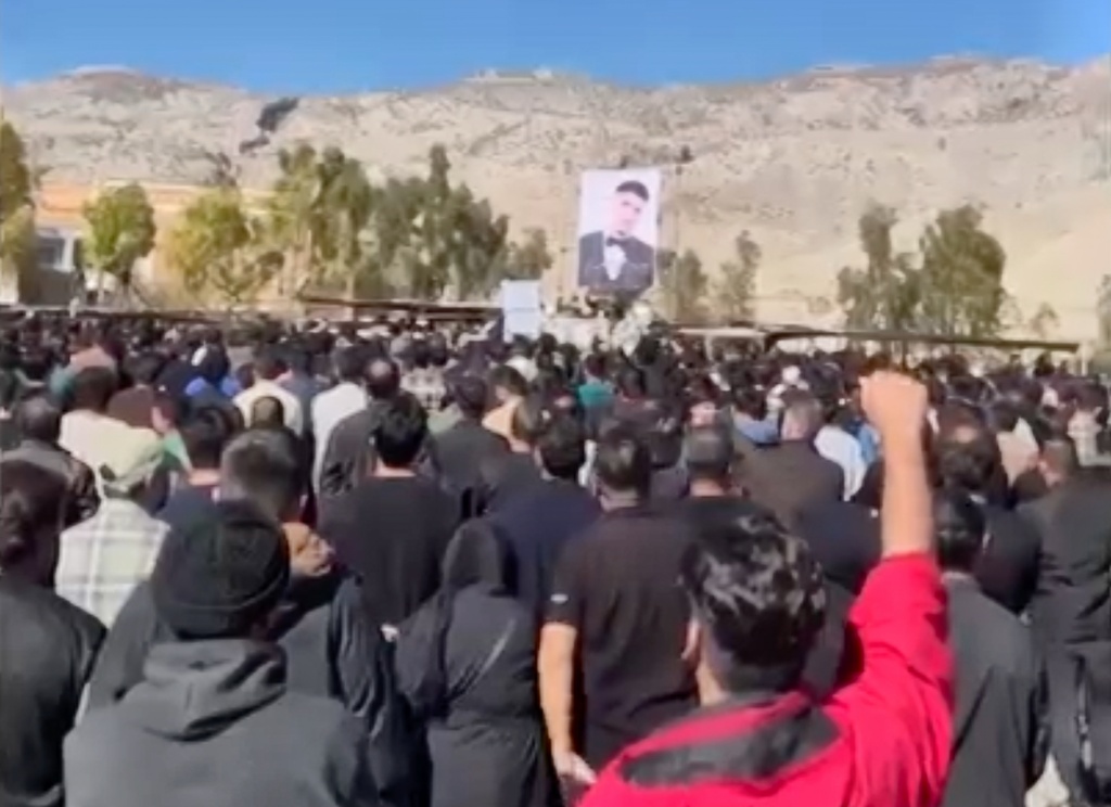 In this image from video circulating on social media, verified by the AP and posted on 17 February, 2026, attendees shout anti-government slogans in Abdanan, Iran, during a memorial known as "chehelom," Persian for "the 40th," marking 40 days since a man was killed during protests. Chehelom ceremonies are traditionally held by families 40 days after a death, but during periods of unrest they can take on a political dimension.(UGC via AP)