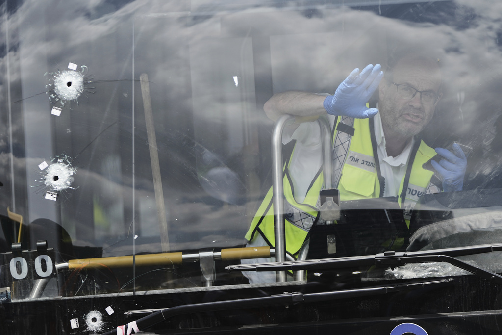 Israeli police and rescue teams inspect the scene of a shooting attack carried out by two Palestinian gunmen, in which several people were killed and others injured at a bus stop in Jerusalem, Monday, Sept. 8, 2025. (AP Photo/Mahmoud Illean)