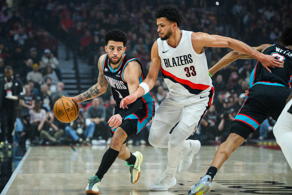 Memphis Grizzlies guard Scotty Pippen Jr. (1) dribbles past Portland Trail Blazers forward Toumani Camara (33) during the first half of an NBA basketball game Friday, Feb. 6, 2026, in Portland, Ore. (AP Photo/Molly J. Smith)