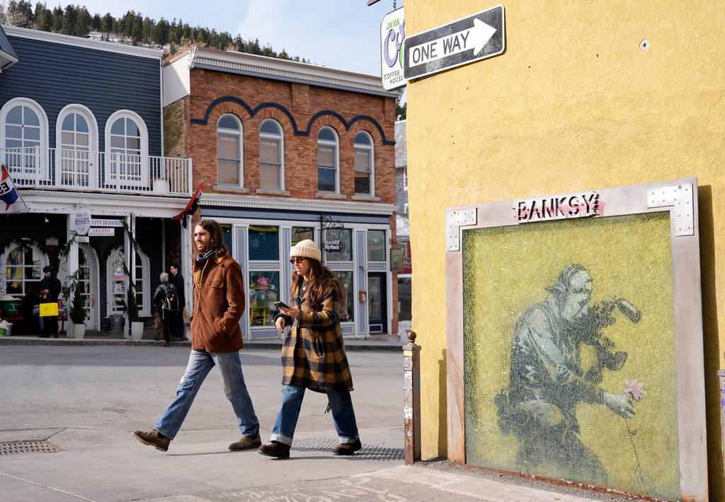 People walk past the Banksy street art piece "Cameraman and Flower" on the opening day of the 2026 Sundance Film Festival on Thursday, Jan. 22, 2025 in Park City, Utah. (AP Photo/Chris Pizzello)