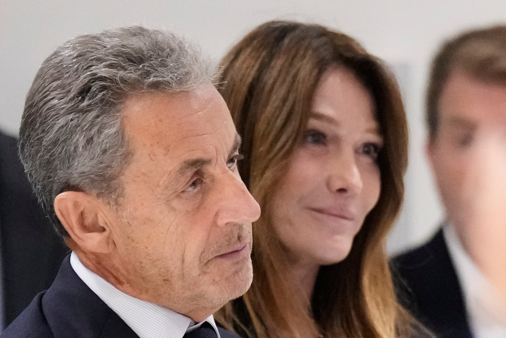 Former French President Nicolas Sarkozy, next to his wife Carla Bruni Sarkozy, speaks after a Paris court sentenced him to 5 years in prison and said he'll be incarcerated even if he appeals, after finding him guilty in his trial for alleged illegal campaign financing by Libya, Thursday, Sept. 25, 2025 in Paris. (AP Photo/Michel Euler)