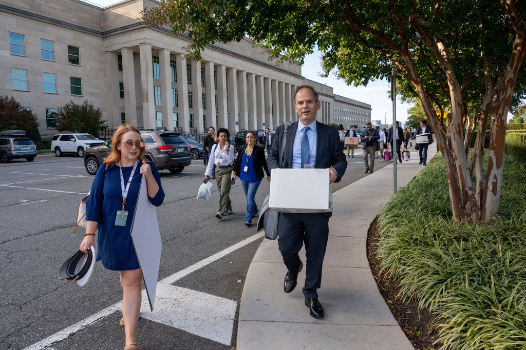 Members of the Pentagon press corp carry their belongings out of the Pentagon after turning in their press credentials, Wednesday, Oct. 15, 2025 in Washington. (AP Photo/Kevin Wolf)