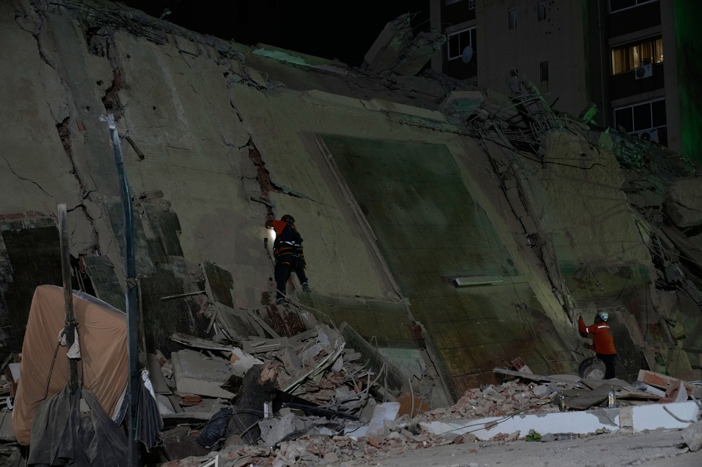 Rescue workers comb through the rubble of a collapsed building after an earthquake in Caracas, Venezuela, Thursday, June 25, 2026. (AP Photo/Ariana Cubillos)