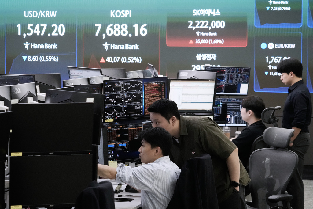 Currency traders watch monitors near a screen showing the Korea Composite Stock Price Index (KOSPI) and the foreign exchange rate between U.S. dollar and South Korean won at the foreign exchange dealing room of the Hana Bank headquarters in Seoul, South Korea, Friday, July 3, 2026. (AP Photo/Ahn Young-joon)