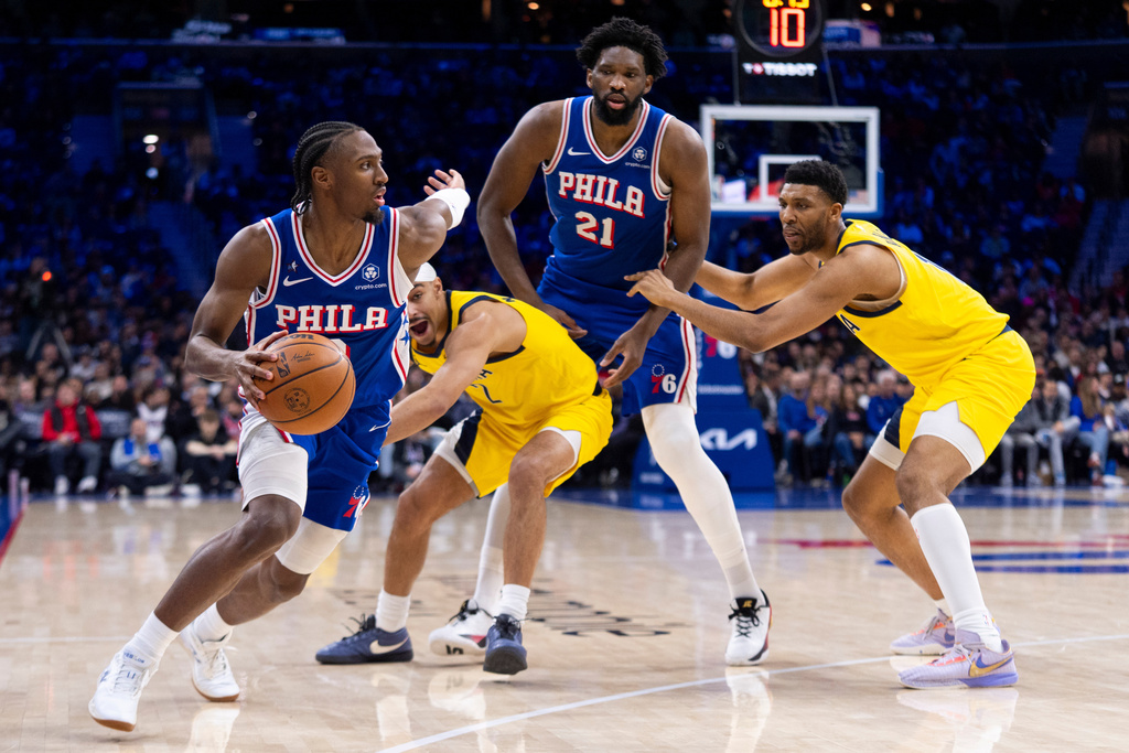 Philadelphia 76ers' Tyrese Maxey, left, uses Joel Embiid (21) as a screen against Indiana Pacers' Andrew Nembhard, center left, as he makes his way to the basket during the first half of an NBA basketball game, Monday, Jan. 19, 2026, in Philadelphia. (AP Photo/Chris Szagola)
