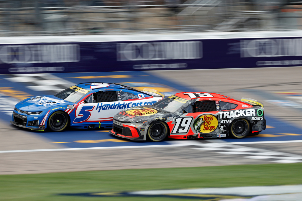 Kyle Larson (5) and Chase Briscoe (19) battle for first place during the third stage of a NASCAR Cup Series auto race in Kansas City, Kan., Sunday, Sept. 27, 2026. (AP Photo/Colin E. Braley)