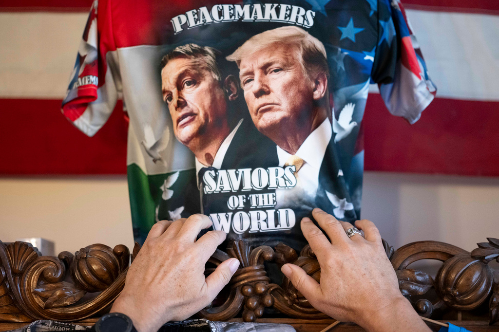Akos Szilagyi, one of Viktor Orban's most prominent supporters, adjusts one of his self-designed T-shirts, featuring Orban and U.S. President Donald Trump, at his home in Budapest, Hungary, Tuesday, April 14, 2026. (AP Photo/Denes Erdos)