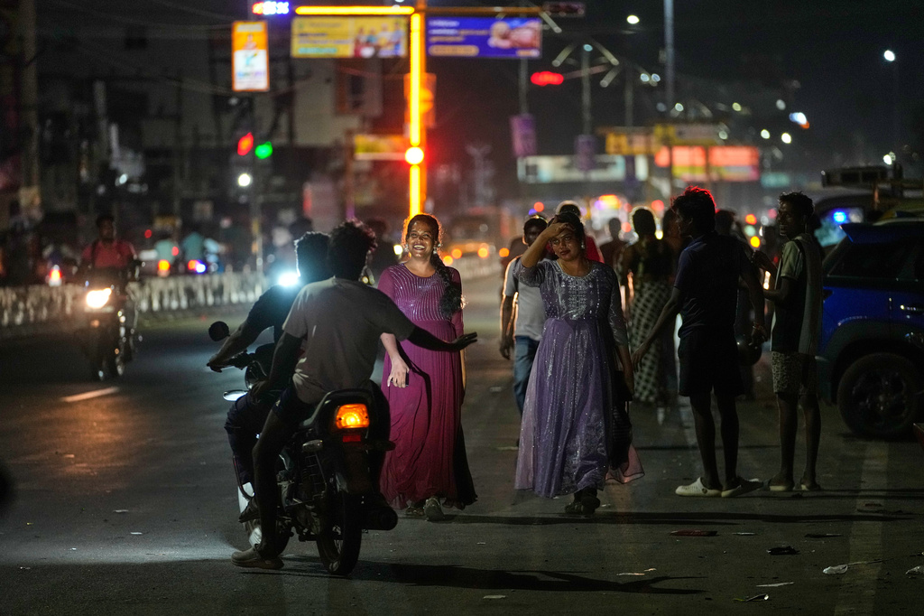 A motorist teases a group of transgender participants walking along a street after they attended the Miss Koovagam beauty pageant in Villupuram, Tamil Nadu, India, Monday, April 27, 2026. (AP Photo/Mahesh Kumar A.)