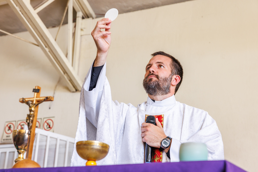 The Rev. Brian Strassburger elevates the host at the altar during Mass at Casa del Migrante on Thursday, March 19, 2026, in Reynosa, Mexico. (AP Photo/Michael Gonzalez)