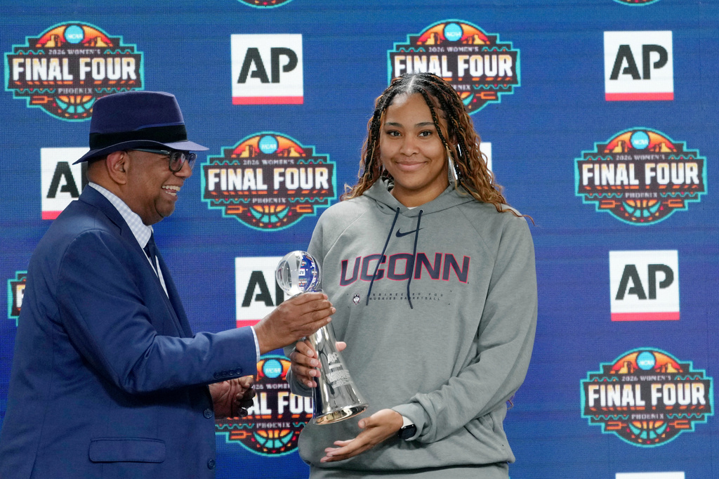Associated Press deputy global sports editor Oscar Dixon, left, presents UConn's Sarah Strong with the 2026 AP Women's Player of the Year award during a news conference at the Women's Final Four of the NCAA college basketball tournament, Thursday, April 2, 2026, in Phoenix. (AP Photo/Ross D. Franklin)