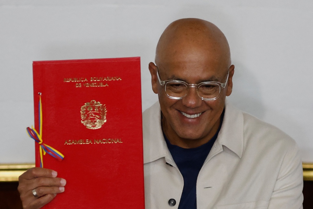 National Assembly President Jorge Rodriguez holds up a document during a debate on a mining bill at the National Assembly in Caracas, Venezuela, Monday, March 9, 2026. (AP Photo/Pedro Mattey)