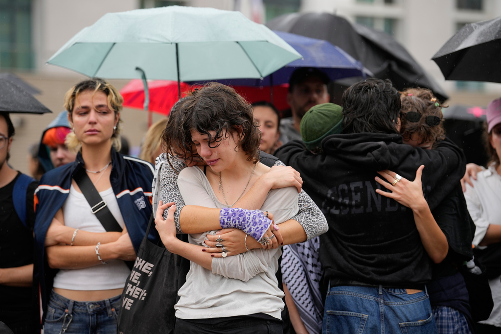 People gather outside the Brandenburg Gate for a demonstration in support of LGBTQ+ after a car rammed into a crowd at the Pride March in Berlin, Sunday, July 26, 2026. (AP Photo/Ebrahim Noroozi)