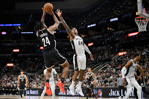 Brooklyn Nets guard Cam Thomas, center left, shoots against San Antonio Spurs guard Devin Vassell, center right, during the first half of an NBA basketball game, Sunday, Oct. 26, 2025, in San Antonio. (AP Photo/Darren Abate) Brooklyn Nets guard Cam Thomas, center left, shoots against San Antonio Spurs guard Devin Vassell, center right, during the first half of an NBA basketball game, Sunday, Oct. 26, 2025, in San Antonio. (AP Photo/Darren Abate)