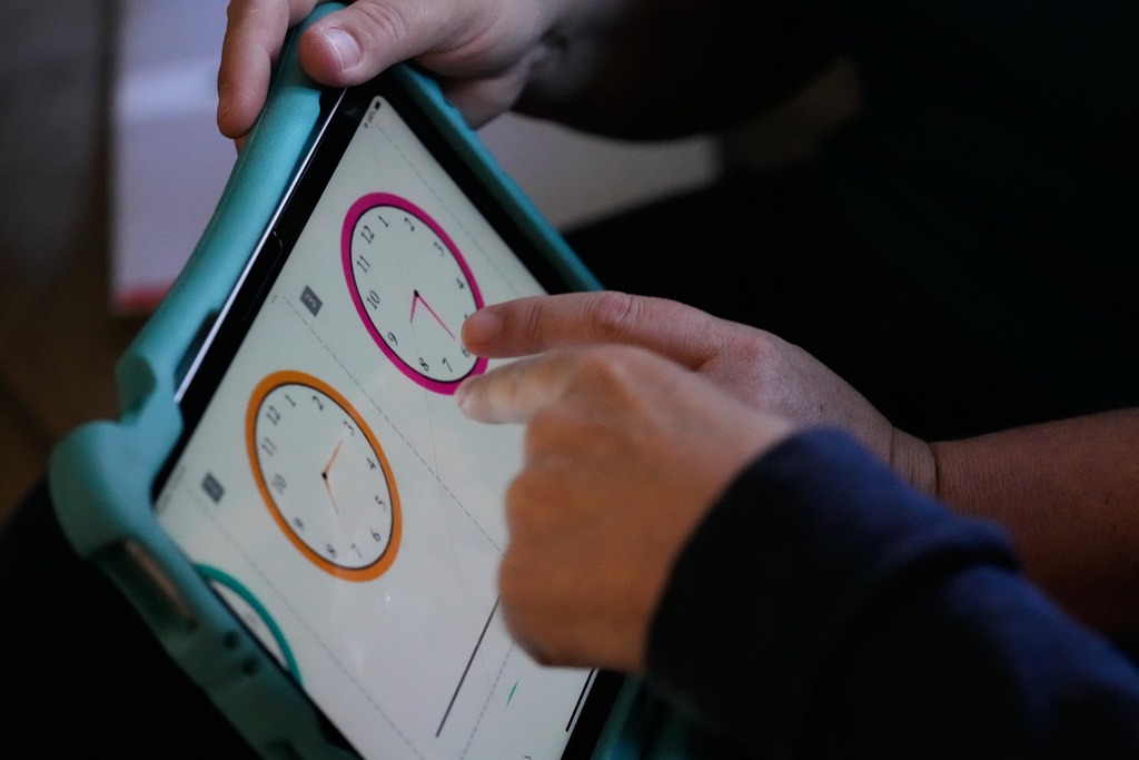 Bill Swick, bottom hand, points as he studies with his wife Martha Swick at their home in Minooka, Ill., Friday, Oct. 24, 2025. (AP Photo/Nam Y. Huh)