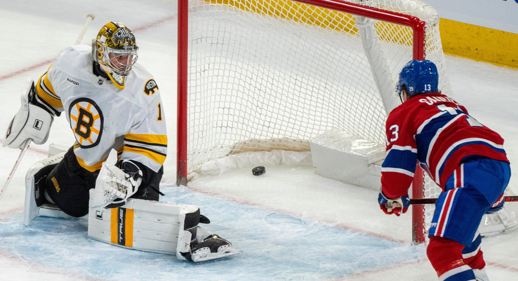 Montreal Canadiens' Cole Caufield (13) scores on Boston Bruins goaltender Jeremy Swayman (1) during overtime NHL hockey action in Montreal on Tuesday, March 17, 2026. (Christinne Muschi/The Canadian Press via AP)