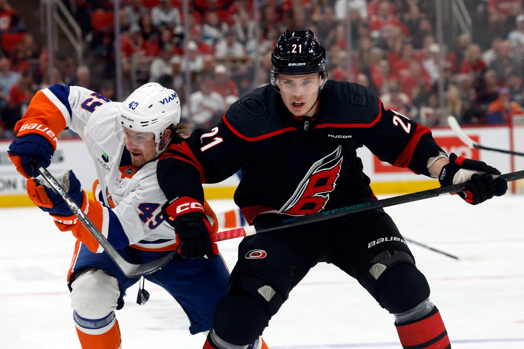 Carolina Hurricanes' Alexander Nikishin (21) battles for position with New York Islanders' Max Shabanov (49) uring the first period of an NHL hockey game in Raleigh, N.C., Saturday, April 4, 2026. (AP Photo/Karl DeBlaker)